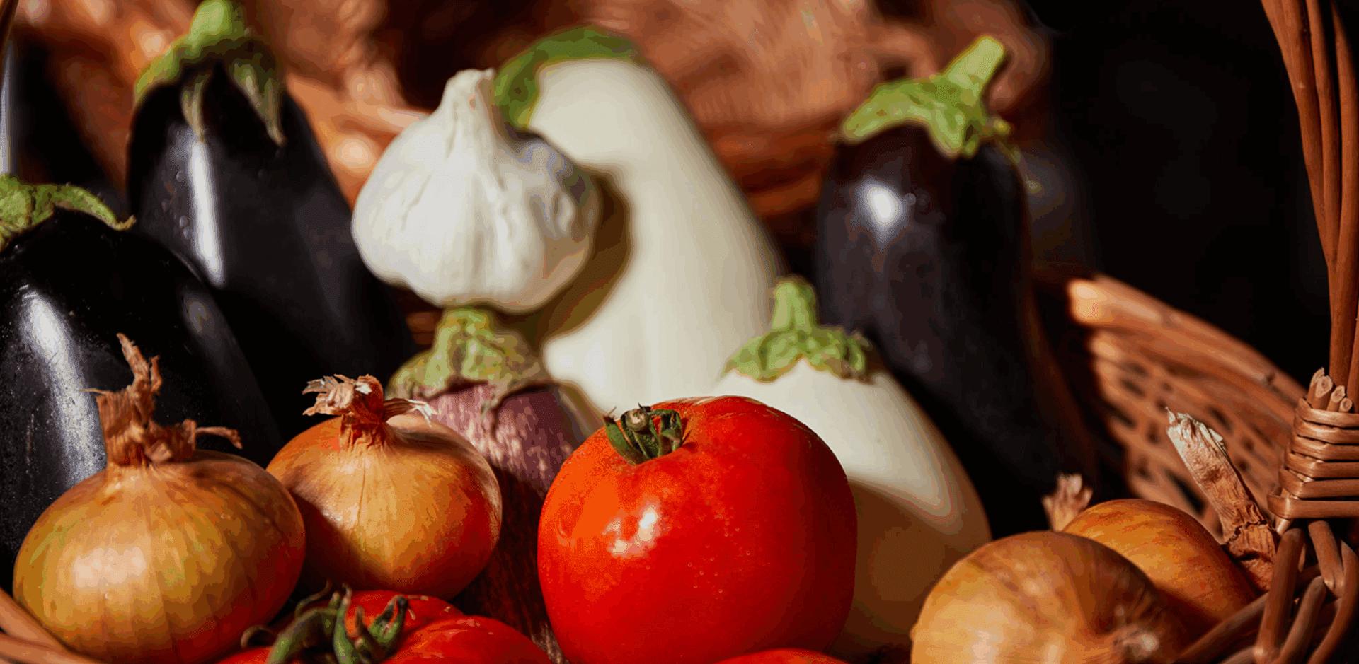 Basket of assorted fresh vegetables, including tomatoes.